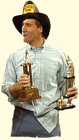 Al Bundy hält 2 Pokale in den Händen und schaut verschmitzt nach links